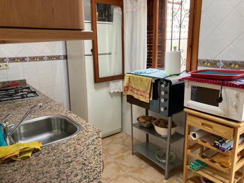 una cocina con fregadero y microondas en una encimera en Duplex familiar, en Puerto de Mazarrón