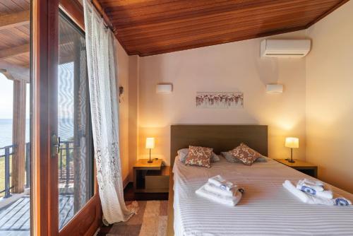 a bedroom with a bed with towels on it at Luna Villa Private Beach in Nea Irakleia