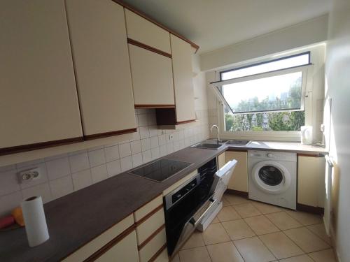 une cuisine avec un évier et une machine à laver dans l'établissement Calm 3 bedrooms & Salon, La Defense, Metro, Parking, à Courbevoie