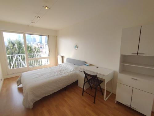 une chambre avec un lit, un bureau et une fenêtre dans l'établissement Calm 3 bedrooms & Salon, La Defense, Metro, Parking, à Courbevoie
