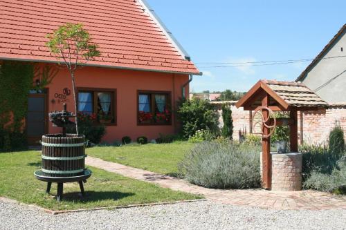 a house with a trash can in the yard at Ottó Panzió Villány in Villány