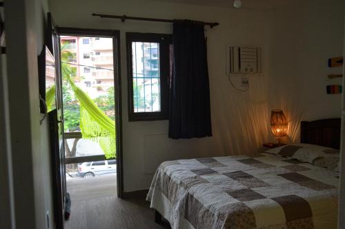a bedroom with a bed and a window at temporada praia do forte cabo frio in Cabo Frio