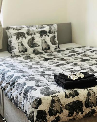a bed with a black and white comforter on it at SIMPLE 2BED FLAT IN EDINBURGH. in Edinburgh