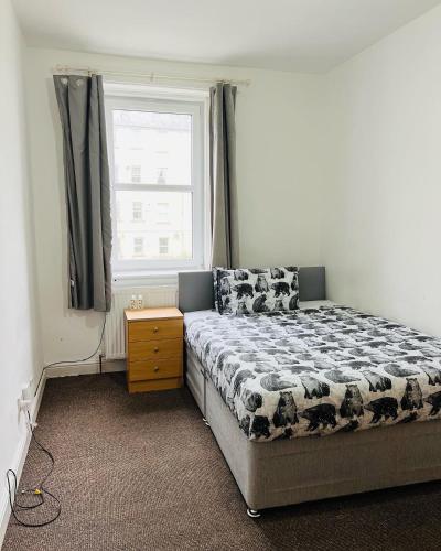 een slaapkamer met een bed en een raam bij SIMPLE 2BED FLAT IN EDINBURGH. in Edinburgh