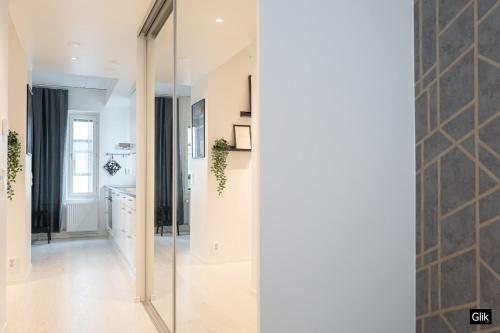 un couloir avec une porte en verre menant à une cuisine dans l'établissement Spacious and cozy, well equipped, 2 bedroom apartment in great location, à Tampere