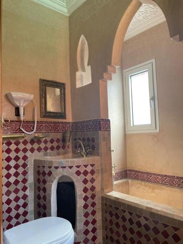 een badkamer met een toilet en een betegelde open haard bij Riad Charlie in Marrakesh