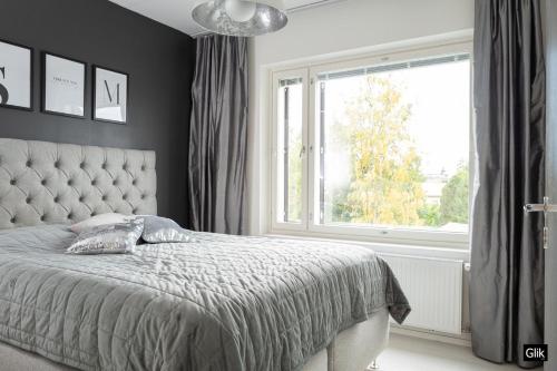 een slaapkamer met een bed en een groot raam bij Spacious and cozy, well equipped, 2 bedroom apartment in great location in Tampere
