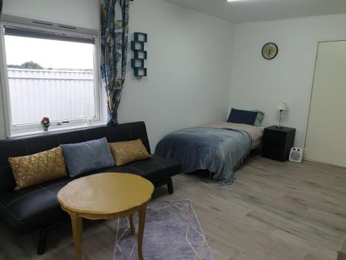 a living room with a couch and a bed at Comfortable apartment, 10min Airport in Stavanger