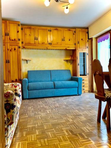 a blue couch in a living room with wooden cabinets at Profumo di Legno in Valtournenche