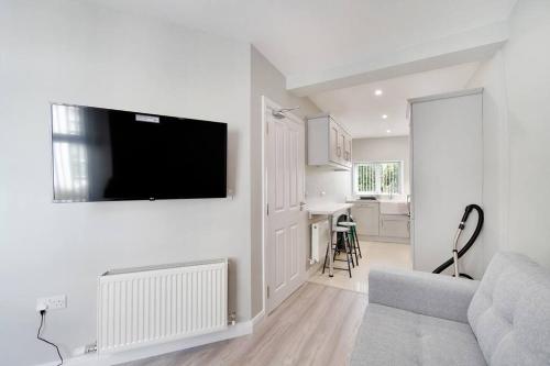 a living room with a couch and a tv on a wall at HillTop View 'Sleeping 5 guests' in Derry Londonderry