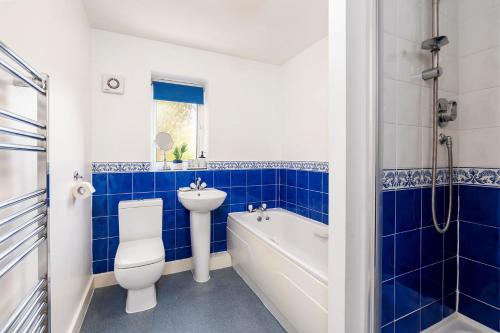 a blue and white bathroom with a toilet and a sink at Lakeside Reach in Doncaster