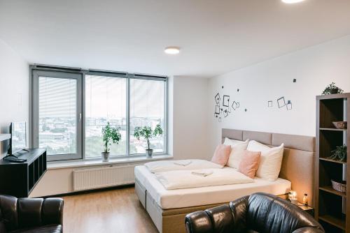 ein Schlafzimmer mit einem Bett und einem großen Fenster in der Unterkunft Flora Cozy Apartment in Bratislava