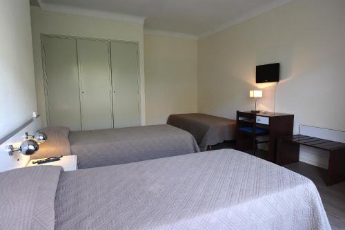 a hotel room with two beds and a desk at Sun Beach in Ajaccio
