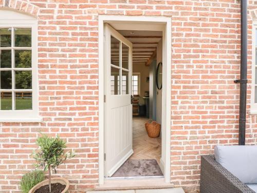 an open door into a brick house at The Stable at Warren House in Market Rasen