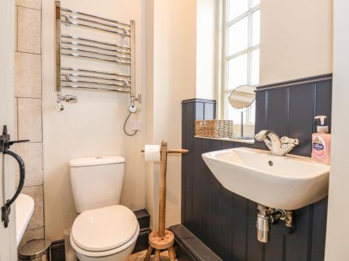 a bathroom with a white toilet and a sink at The Stable at Warren House in Market Rasen