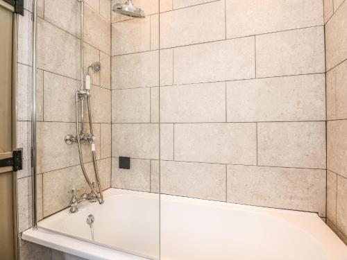 a bathroom with a shower with a tub at The Stable at Warren House in Market Rasen