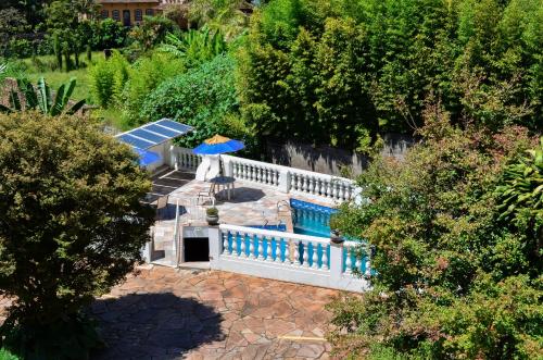 uma vista superior de uma piscina com uma cerca e um guarda-sol em Hotel Solar de Maria em Ouro Preto