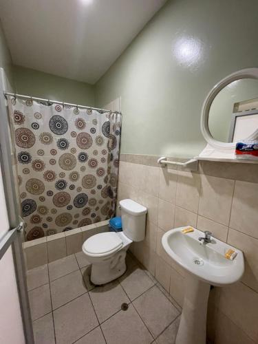 a bathroom with a toilet and a sink and a shower at Alojamiento Tahuari - Iquitos- Perú in Iquitos