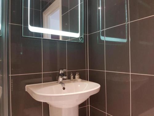a bathroom with a white sink and a mirror at Captivating 2-Bed Apartment in Brentwood in Brentwood