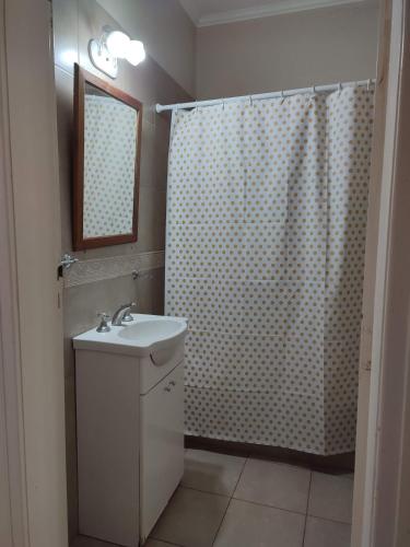 a bathroom with a sink and a shower curtain at La Emilia in San Pedro