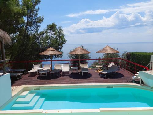 una piscina con sedie e ombrelloni su una terrazza di Resort Luna Rossa a Sperlonga