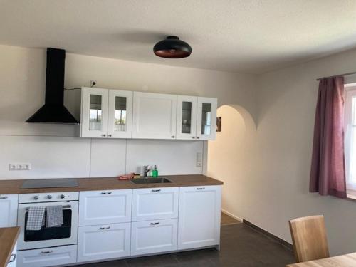 a kitchen with white cabinets and a sink at Pferdehof Thomayer in Strasswalchen