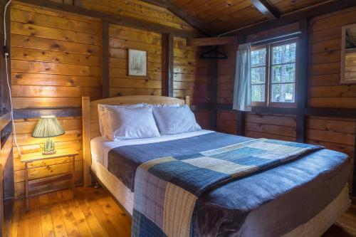 um quarto com uma cama num chalé de madeira em Timbers Resort em Fairmont Hot Springs