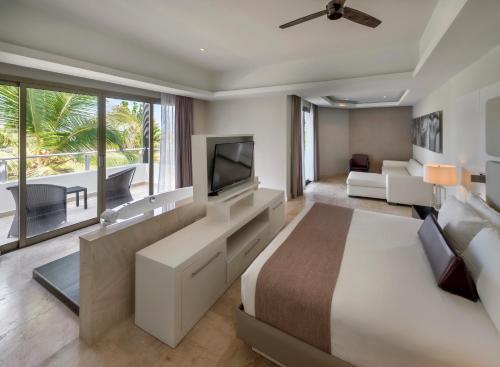 a hotel room with a bed and a tv at Royalton CHIC Punta Cana, An Autograph Collection All-Inclusive Resort & Casino, Adults Only in Punta Cana