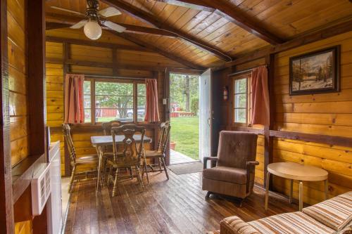 una sala da pranzo in una baita di tronchi con tavolo e sedie di Timbers Resort a Fairmont Hot Springs