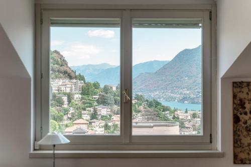 a window with a view of a city at I D'A Charming Penthouse - LAKE VIEW- Como- House-130 mt-2 double bedrooms and 2 double bathrooms a spacious living room-Full equipped kitchen-Private garden and terrace-Private covered parking in Como