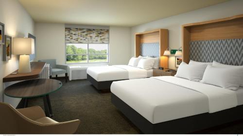 Habitación de hotel con 2 camas y escritorio en Holiday Inn Indianapolis - Airport Area N, an IHG Hotel en Indianápolis