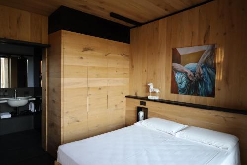 una camera da letto con un letto e un dipinto sul muro di Roggia dei Cedri a Valdobbiadene