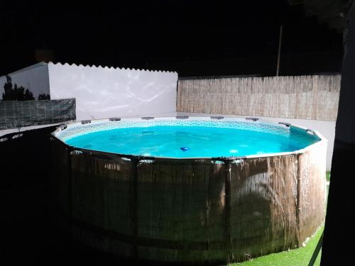 a large blue pool in a backyard at night at Cantinho do Sol in Grândola