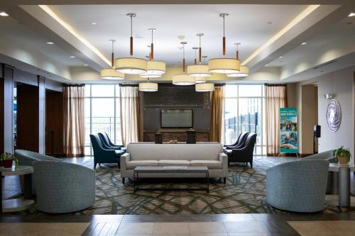 a lobby with a couch and chairs and a television at Holiday Inn Hotel & Suites Northwest San Antonio, an IHG Hotel in San Antonio