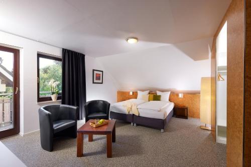 a hotel room with a bed and a chair at Smart-Living in Winterberg