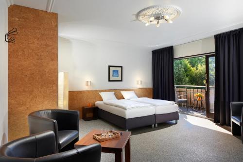 ein Hotelzimmer mit einem Bett, einem Tisch und Stühlen in der Unterkunft Smart-Living in Winterberg