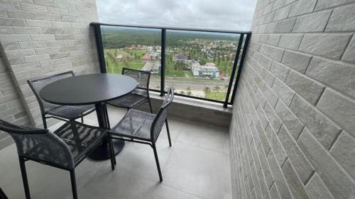 een tafel en stoelen in een kamer met een groot raam bij Apartamento Salinas Premium Resort in Salinópolis