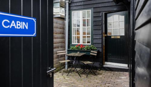 ein schwarzes Haus mit einem Fenster und einem Tisch mit Blumen in der Unterkunft The Cabin at Zwolle Centraal in Zwolle