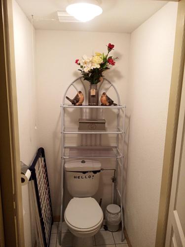 a bathroom with a toilet and a vase of flowers at Le Roi du Sundgau près de la Horse - Mooslargue in Mooslargue