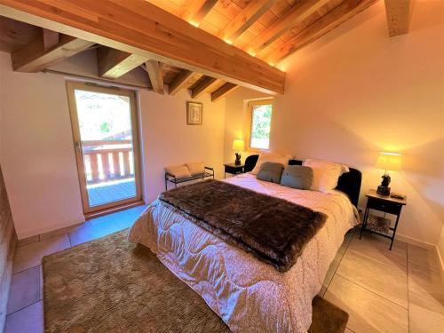 une chambre avec un lit et une grande fenêtre dans l'établissement Appartement chaleureux, 3 chambres, terrasses, parking - FR-1-598-108, aux Gets