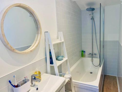 a bathroom with a sink and a mirror and a tub at Beach home with garden, close to New Forest in Bournemouth