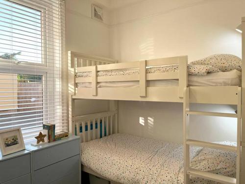 a bedroom with two bunk beds and a window at Beach home with garden, close to New Forest in Bournemouth