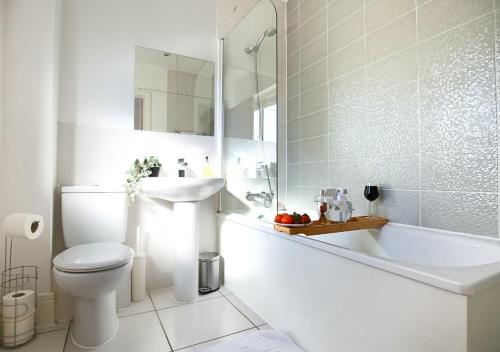 een witte badkamer met een toilet en een wastafel bij Spacious House - Close to City Centre - Free Parking, Fast Wifi, Smart TVs with Netflix by Yoko Property in Milton Keynes