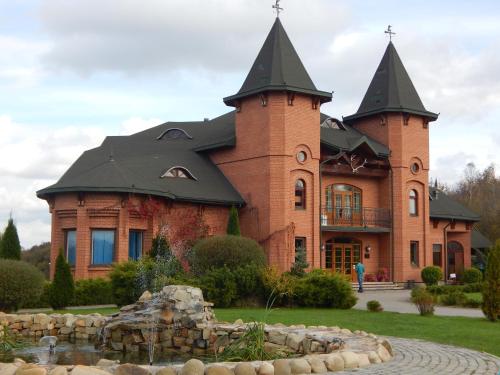 a large brick building with a fountain in front of it at Shepilska Relax Complex in Dovholuka