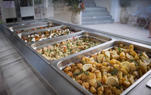 a buffet with many trays of different types of food at Matilda Hotel in Vasilikos