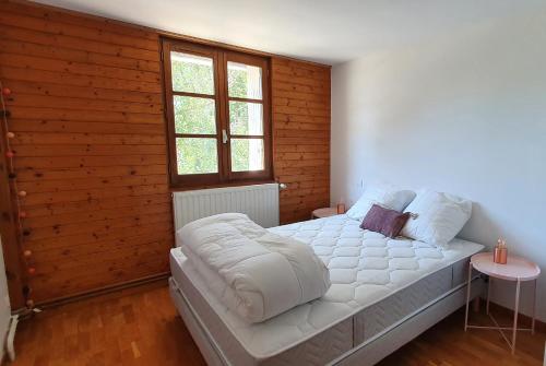 a bedroom with a white bed with a window at Gite Puy De Dôme in Aydat