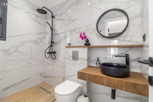 a white bathroom with a sink and a mirror at Greek Dream Homes Thimari in Sounio