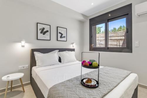 a bedroom with a bed with a bowl of fruit on a table at Greek Dream Homes Thimari in Sounio