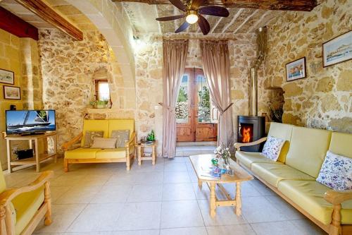 a living room with a couch and a fireplace at Lellux Holiday Home in Nadur