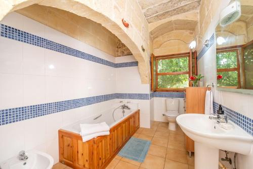 a bathroom with a tub and a sink and a toilet at Lellux Holiday Home in Nadur